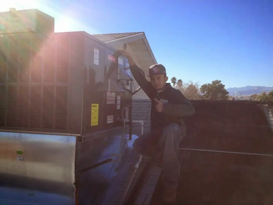 HVAC technician performing Air Duct Cleaning on a rooftop unit in McHenry
